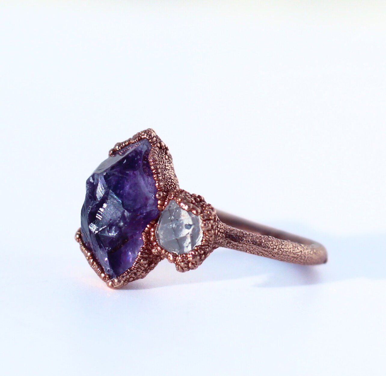A rough, purple amethyst is paired with a tiny Herkimer diamond in this luxe and organic crown chakra ring. Stones are set in copper on a pure, solid copper band.