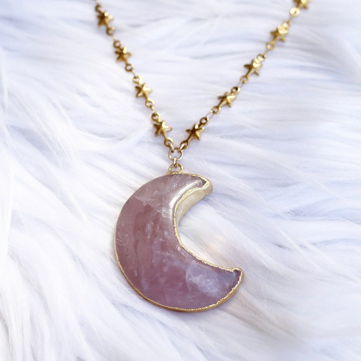 This celestial crystal necklace features a genuine, rose quartz carved moon that is electroformed with gold or silver and attached to your choice of pure stainless steel or gold tone stainless steel tiny star link chain.