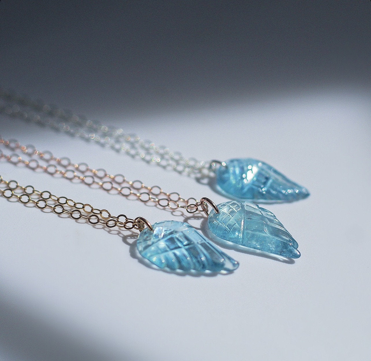 This sweet and dainty angel wing necklace features a carved aquamarine pendant that hangs from delicate, sparkling chain in your choice of 14k gold filled, 14k rose gold filled or sterling silver chain.