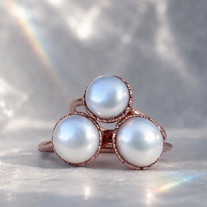 Ring with three pearls on a soft gray background