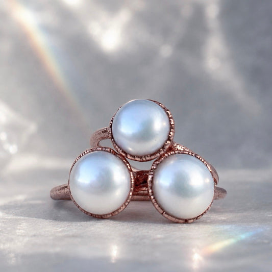 Ring with three pearls on a soft gray background