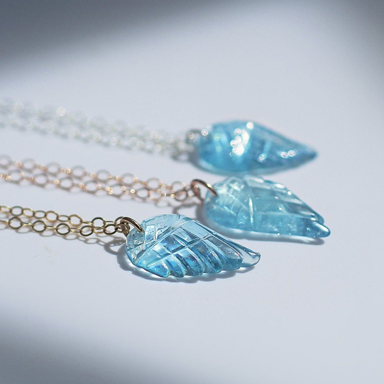 This sweet and dainty angel wing necklace features a carved aquamarine pendant that hangs from delicate, sparkling chain in your choice of 14k gold filled, 14k rose gold filled or sterling silver chain.