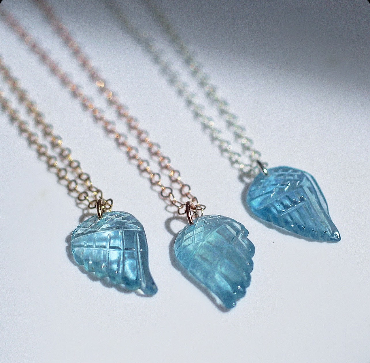 This sweet and dainty angel wing necklace features a carved aquamarine pendant that hangs from delicate, sparkling chain in your choice of 14k gold filled, 14k rose gold filled or sterling silver chain.