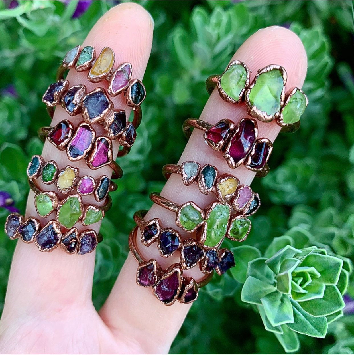 A selection of multi stone rings shown worn on fingers