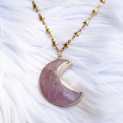 This celestial crystal necklace features a genuine, rose quartz carved moon that is electroformed with gold or silver and attached to your choice of pure stainless steel or gold tone stainless steel tiny star link chain.